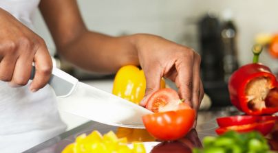 A-black-woman-cutting-a-tomato.jpg